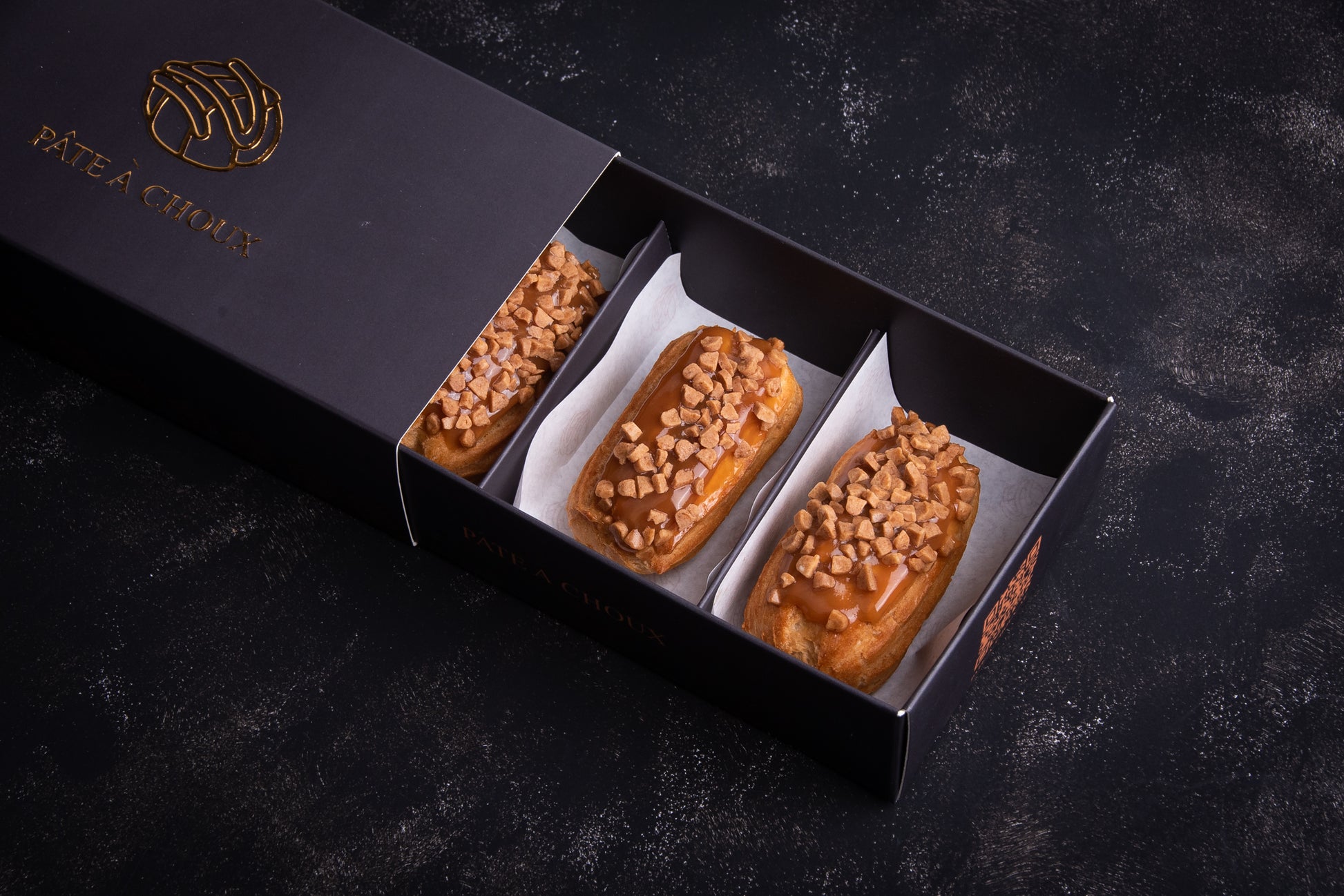 Salted Carmel Mini Éclair in a small box.