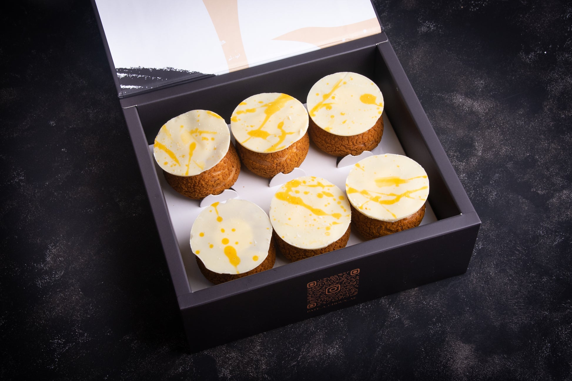 A box of Yuzu Craquelins, with each piece having a golden-brown topping.