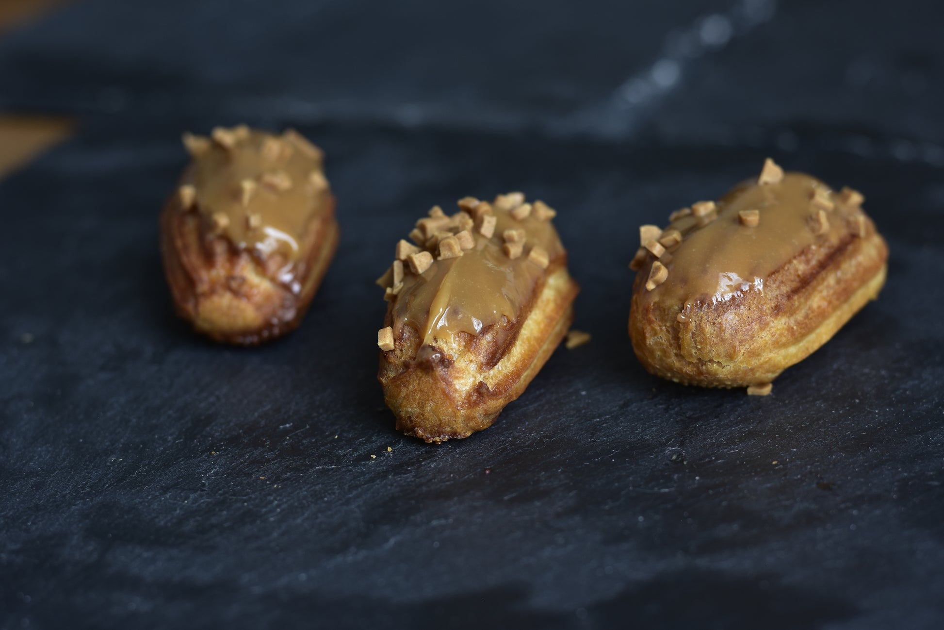 Salted caramel with glazed caramel topping, arranged on a black surface.